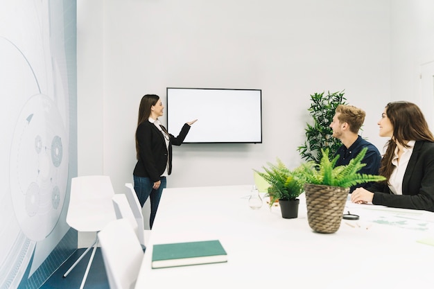 Junge Geschäftsfrau, die Darstellung im Büro gibt