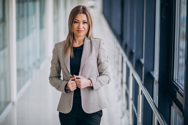 Junge Geschäftsfrau, die durch das Fenster in einem Büro steht