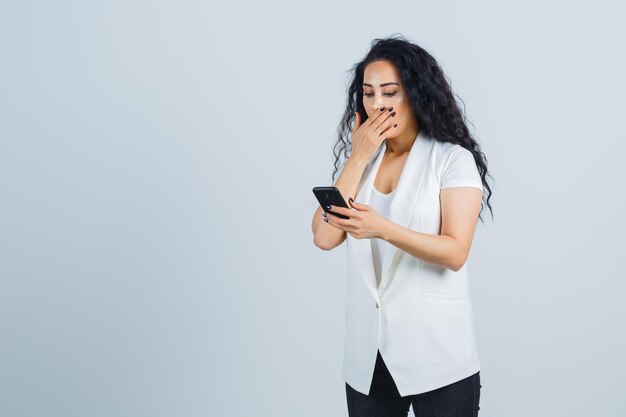 Junge Geschäftsfrau, die ein Telefon hält