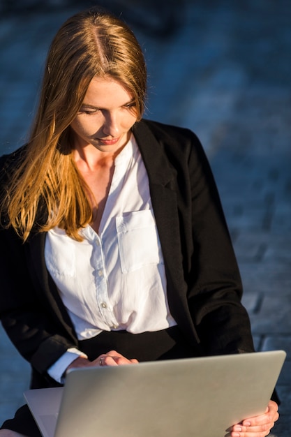 Junge Geschäftsfrau, die ihren Laptop betrachtet