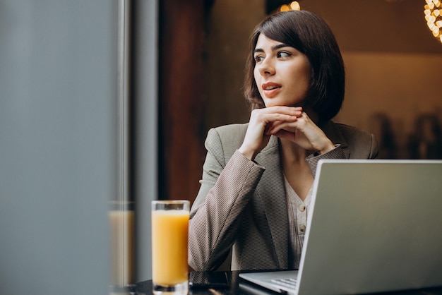 Junge Geschäftsfrau, die in einem Café am Laptop arbeitet