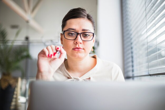 Junge Geschäftsfrau, die Laptop betrachtet