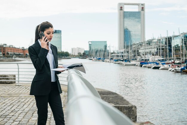 Junge Geschäftsfrau, die nahe dem Hafen steht