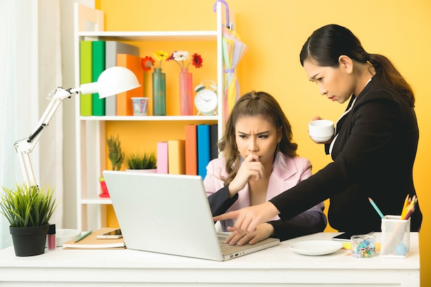 junge Geschäftsfrauen, die im Büro plaudernd sprechen