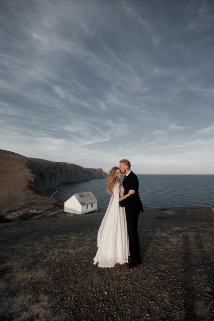 Junge glückliche Braut im Hochzeitskleid und -bräutigam