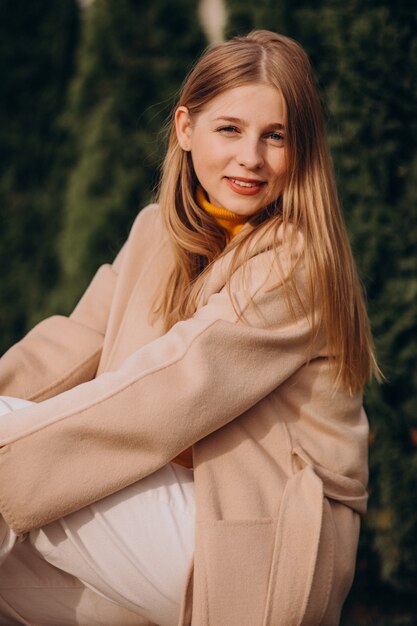 Junge glückliche Frau im beige Mantel