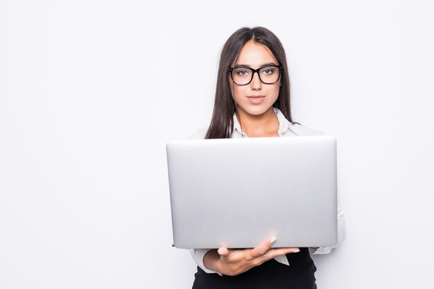 Junge glückliche lächelnde Geschäftsfrau in der Freizeitkleidung, die Laptop hält und E-Mail isoliert auf Weiß sendet