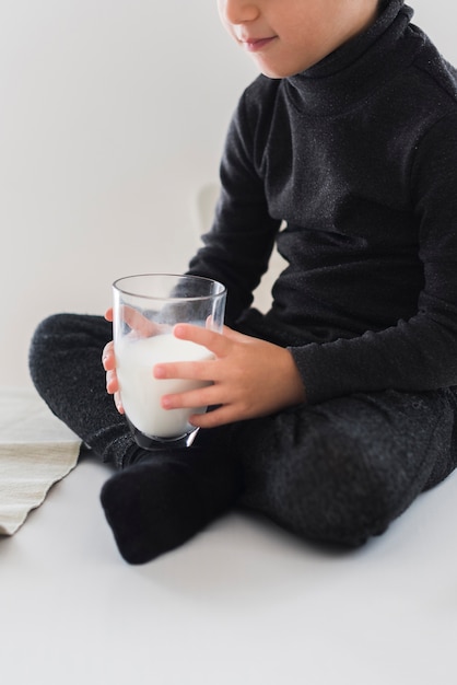 Kostenloses Foto junge hält ein glas milch