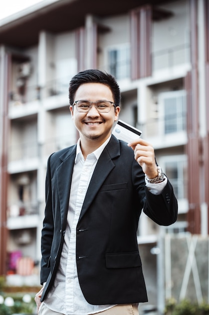 Junge Handsome Mann genießen Online-Shopping auf Handy mit Kreditkarte.