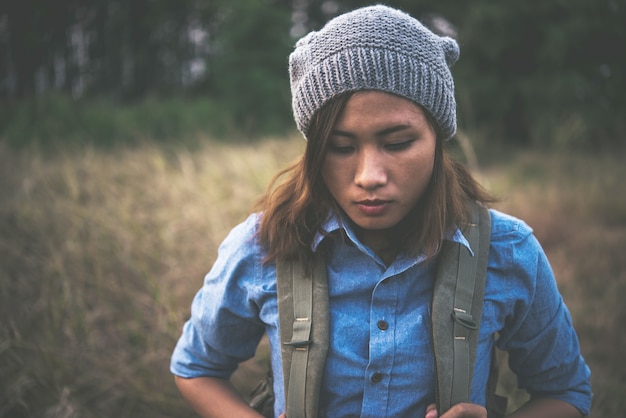 Kostenloses Foto junge hippie-mädchen mit rucksack im sommer feld zu fuß durch.