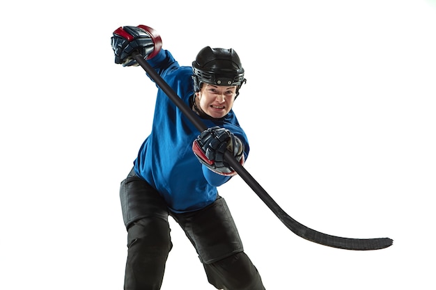 Junge Hockeyspielerin mit dem Stock auf dem Eisplatz und der weißen Wand