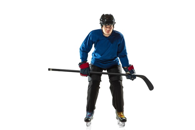 Junge Hockeyspielerin mit dem Stock auf dem Eisplatz und weißem Hintergrund