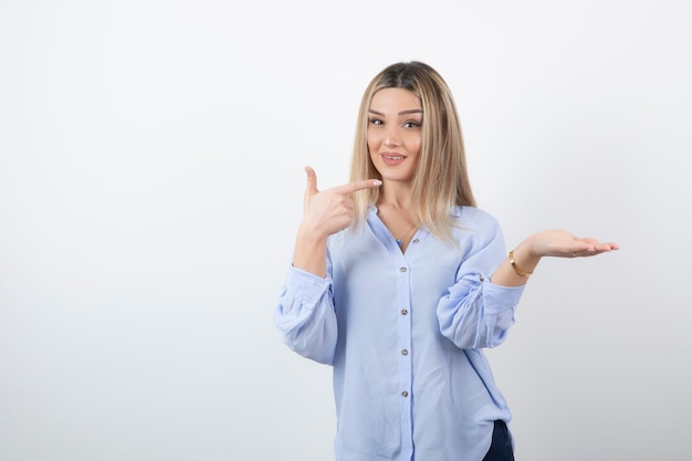 Junge hübsche Frau, die auf weißem Hintergrund steht und aufwirft.