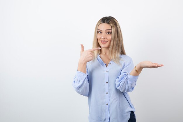 Junge hübsche Frau, die auf weißem Hintergrund steht und aufwirft.