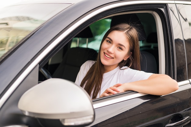 Junge hübsche Frau, die ihr Auto auf Reisestraße fährt