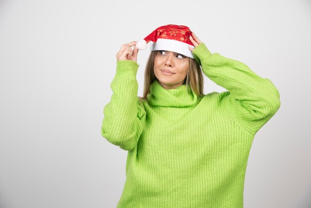 Junge hübsche Frau, die roten Hut des Weihnachtsmanns trägt