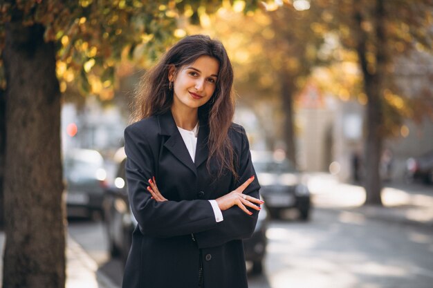 Junge hübsche Frau in der noblen Ausstattung in einer Herbststraße