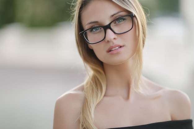 junge hübsche Frau mit Brille im Freien