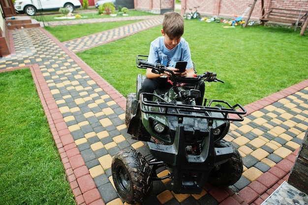 Kostenloses Foto junge im allrad-atv-quad-bike mit handy