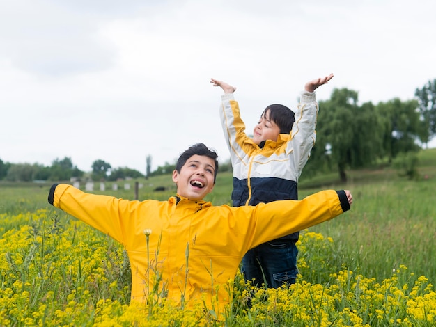 Junge im Regenmantel und sein Bruder umgeben von Blumen