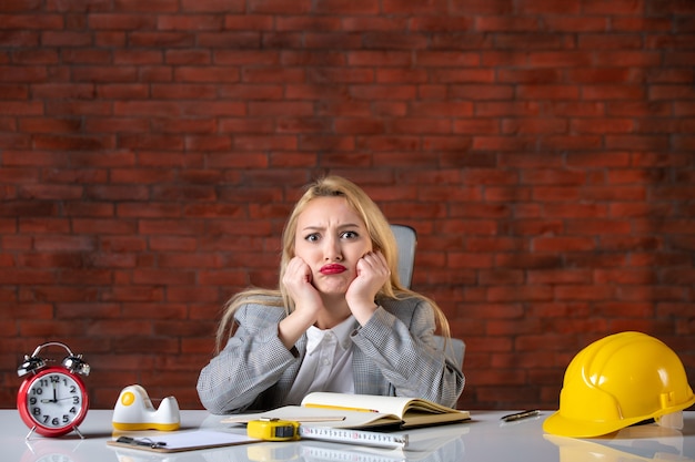 Junge Ingenieurin der Vorderansicht, die am Büro sitzt