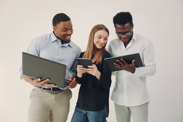 Junge internationale Leute, die zusammenarbeiten und den Laptop benutzen