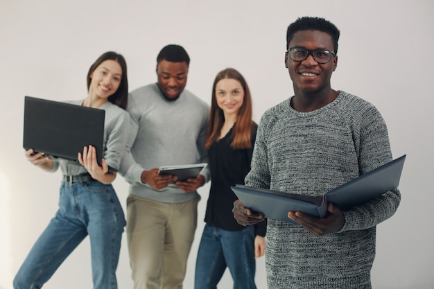 Junge internationale Leute, die zusammenarbeiten und den Laptop benutzen