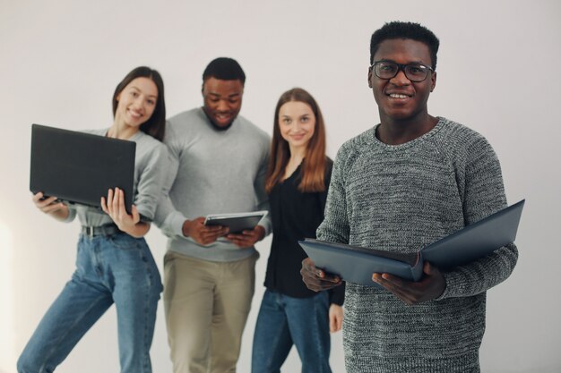 Junge internationale Leute, die zusammenarbeiten und den Laptop benutzen