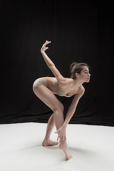 Junge jugendlich tänzer tanzen auf weißem boden studio hintergrund. ballerina-projekt.