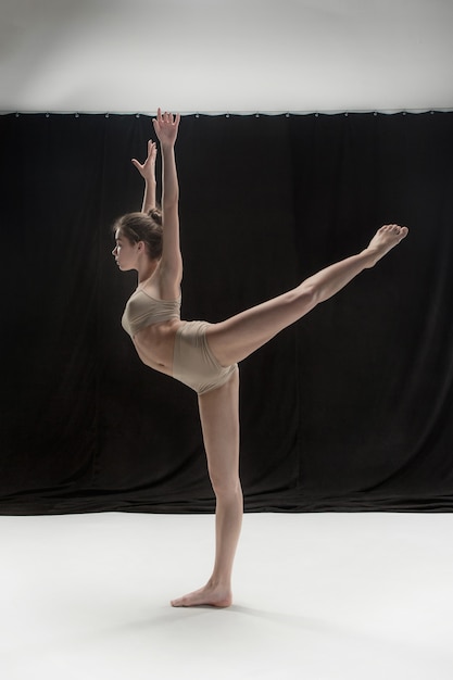 Junge jugendlich tänzer tanzen auf weißem boden studio hintergrund. ballerina-projekt.