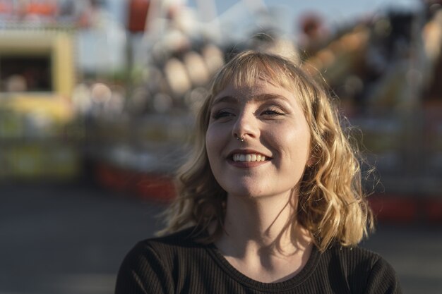 Junge kaukasische Frau, die Zeit im Vergnügungspark verbringt