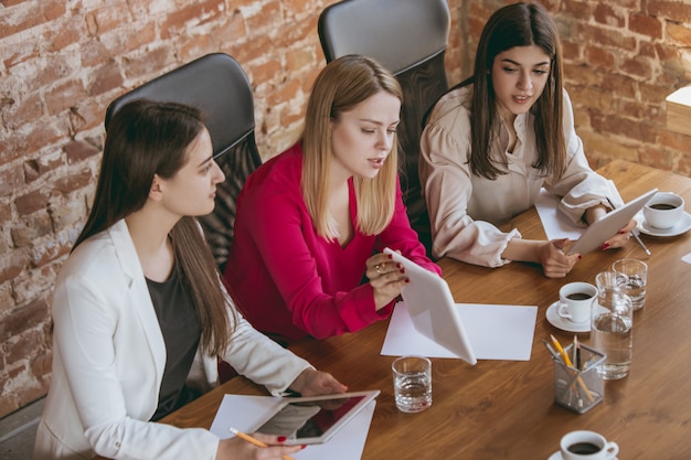 Junge kaukasische Geschäftsfrau im modernen Büro mit Team