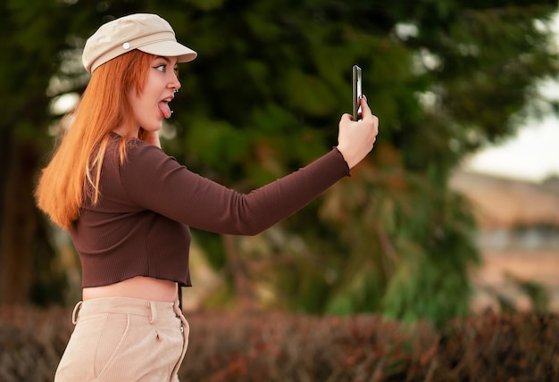 Junge kaukasische rothaarige Frau macht ein Selfie mit einem lustigen Gesicht