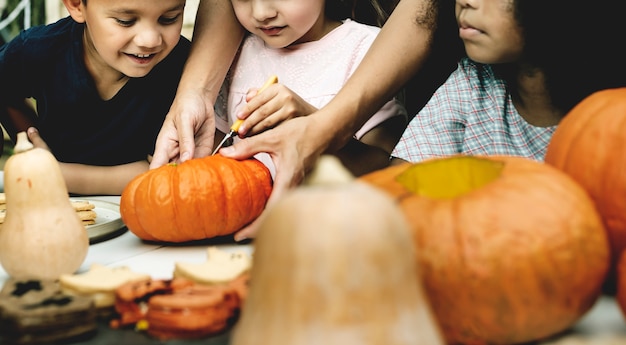 Kostenloses Foto junge kinder, die halloween-jacklaternen schnitzen