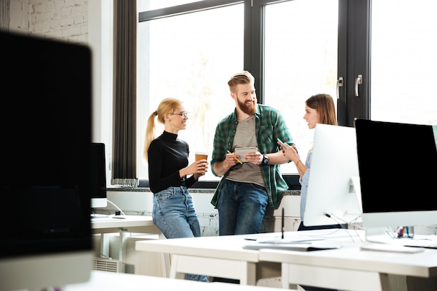 Junge konzentrierte Kollegen im Büro sprechen miteinander