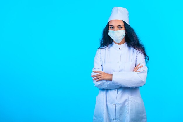 Junge Krankenschwester in isolierter Uniform, die schließende Hände hält und selbstbewusst aussieht