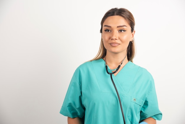 Junge Krankenschwester mit Stethoskop auf weißem Hintergrund