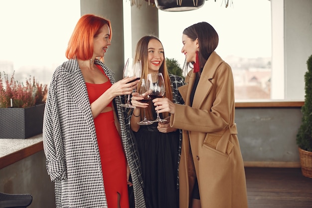 Junge lachende Freunde, die draußen Roséwein aus Glas trinken