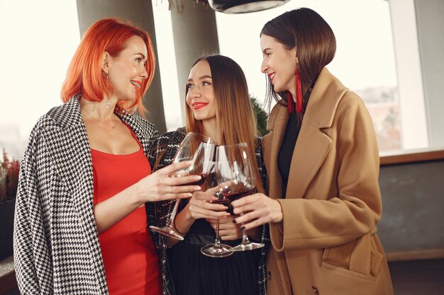 Junge lachende Freunde, die draußen Roséwein aus Glas trinken