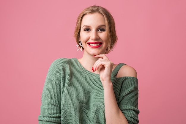 Junge lächelnde glückliche attraktive Frau, rote Lippen und Nagellacke, lässiger Stil, grüner Pullover, fröhliche, positive Emotion, Modell, das im Studio aufwirft, isoliert, rosa Hintergrund, in der Kamera schauend