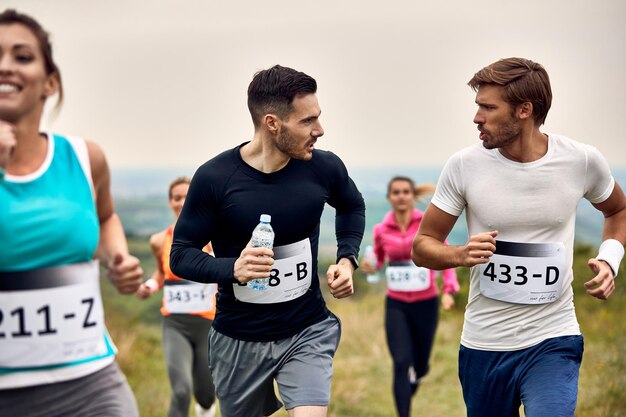 Junge Läufer unterhalten sich während der Teilnahme an einem Marathon in der Natur