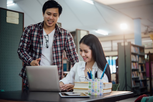 Junge lernende Studenten, Bibliotheksbücherregale