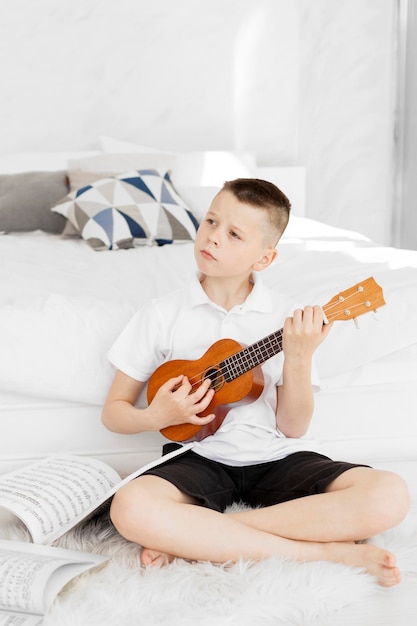 Kostenloses Foto junge lernt, wie man ukulele spielt