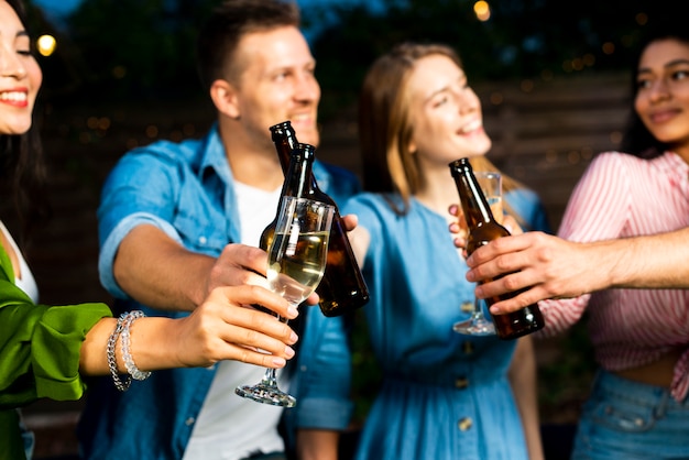 Kostenloses Foto junge leute, die bierflaschen rösten