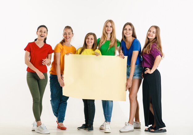 Junge Leute, die in den Farben der LGBT-Flagge getragen werden, isoliert auf der weißen Wand LGBT-Stolz-Konzept