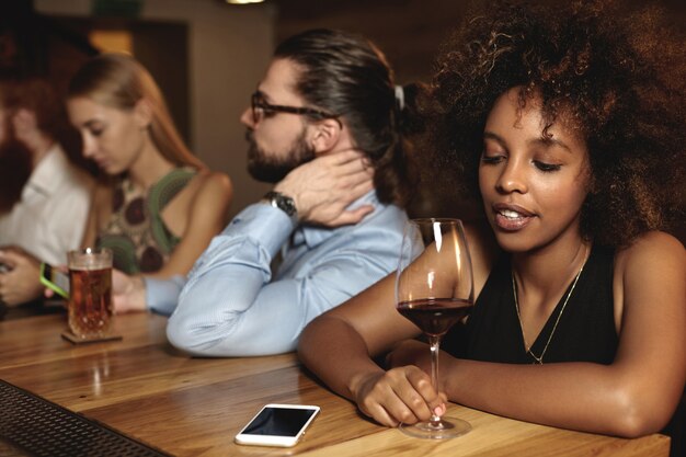 Junge Leute, die in der Bar sitzen und etwas trinken