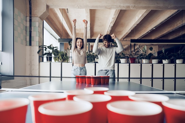 Kostenloses Foto junge leute, die in einem modernen büro bierpong spielen