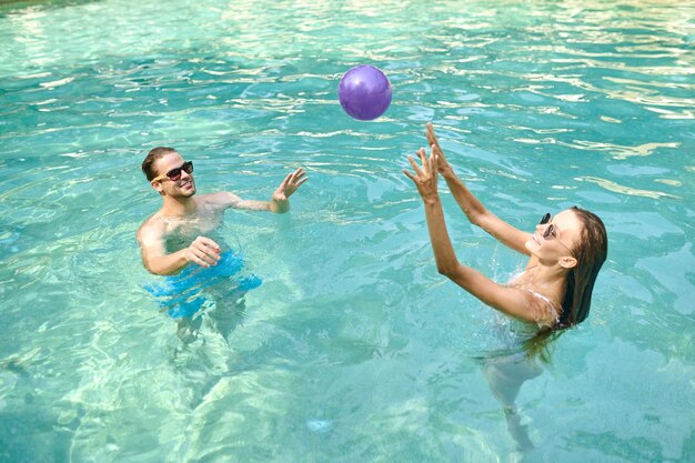 Junge Leute, die Spaß haben und sich am Swimmingpool erfreuen