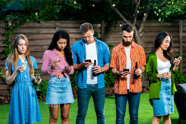 Junge Leute draußen mit dem Telefonsimsen