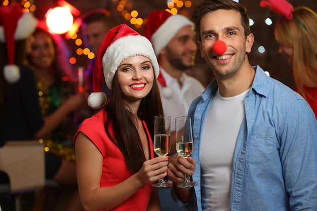 Junge leute mit gläsern champagner auf weihnachtsfeier